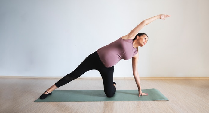 Pregnant person exercising at home
