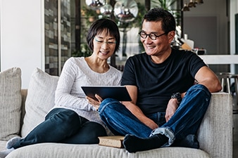 Couple reading a tablet device on a couch