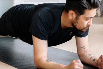 Person holding plank position on yoga mat