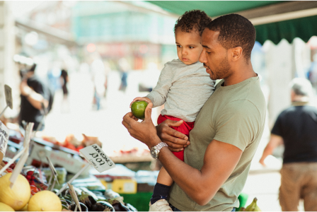 Man holding child in open product market