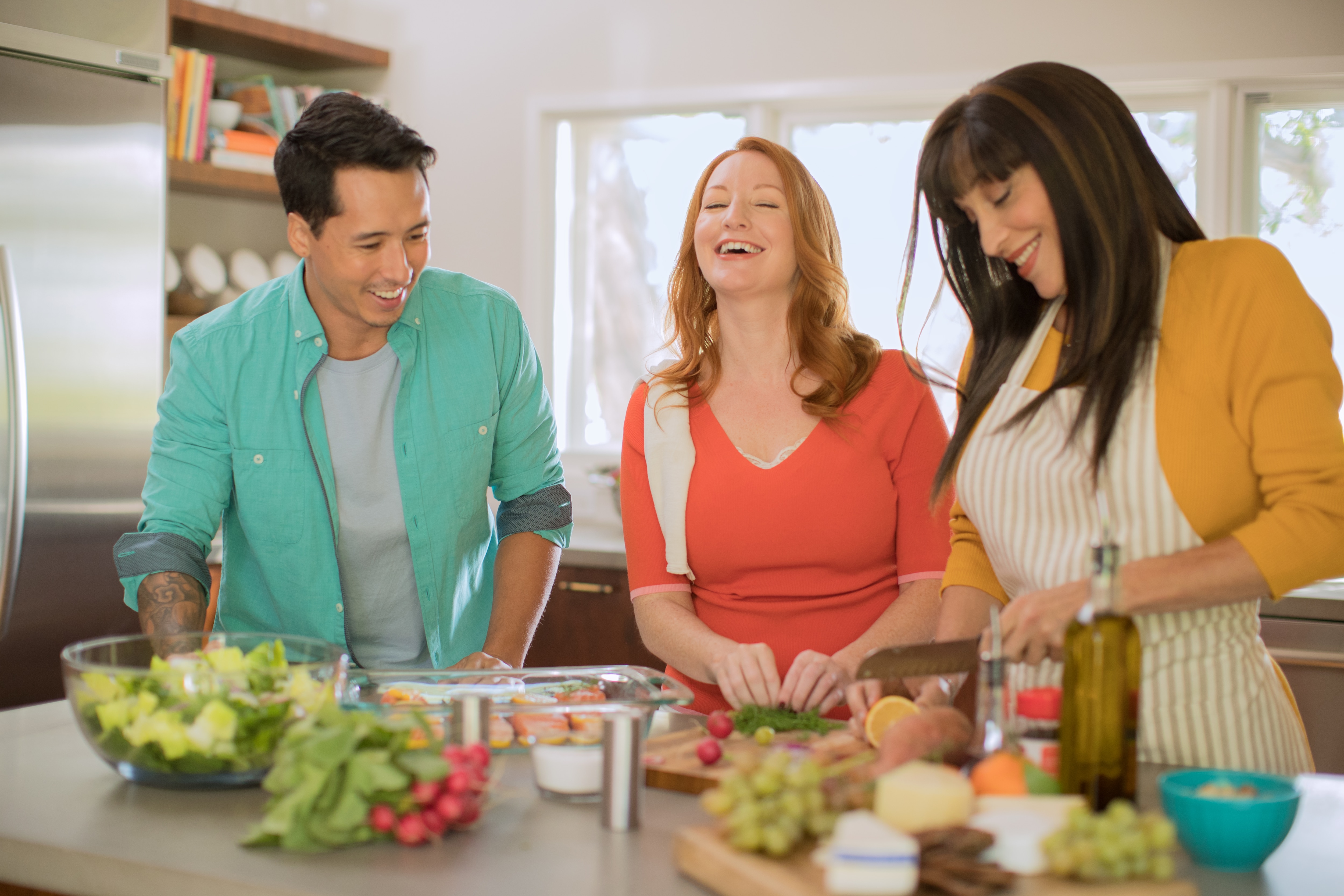 Group of three people cooking in kitchen