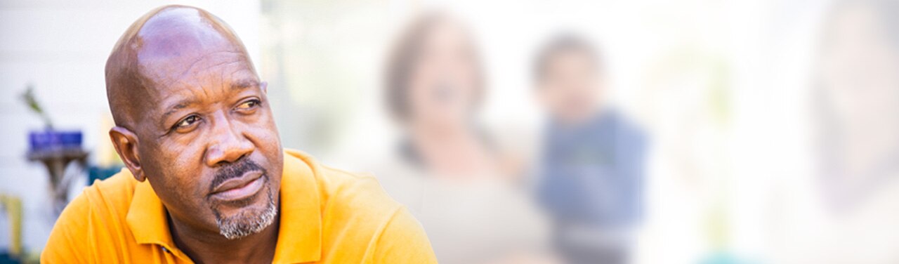 Man in deep thought sits away from group of people