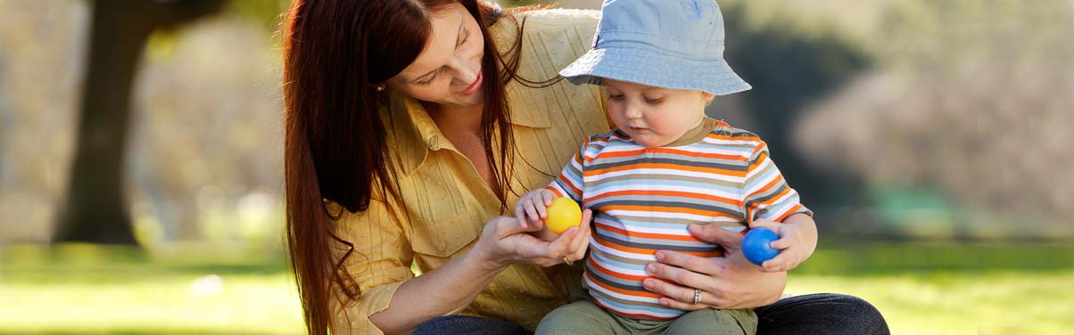 Mother holding baby and playing outside