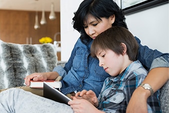 Parent watching child use a tablet