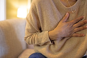 Person holding hand to their chest