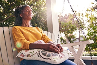 Person meditating outside their home