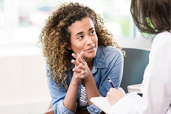 Person sitting in a chair talking to a therapist