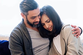 Person sitting on a couch and leaning on their partner