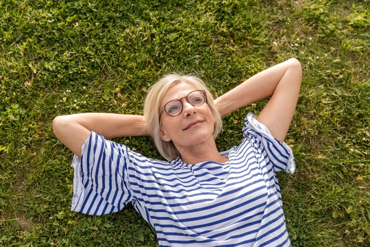 woman in glasses laying on the grass