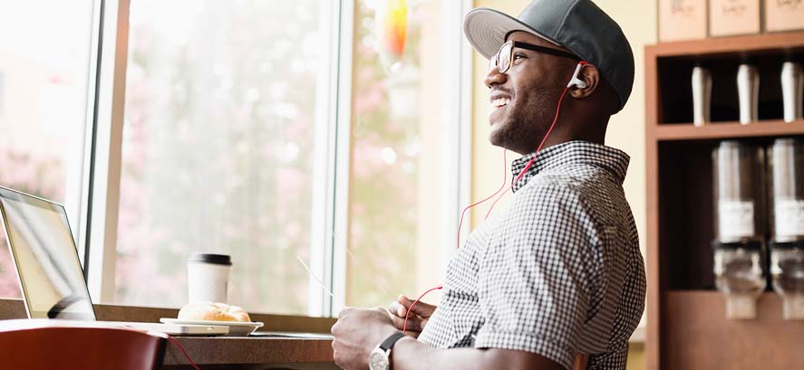 Smiling man with headphones and baseball cap