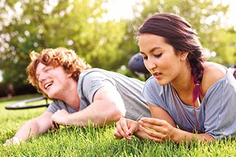 Two people laying in the grass together