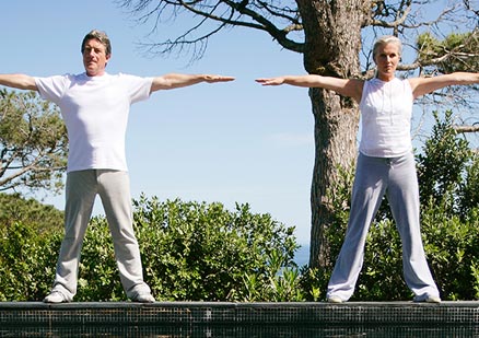 Two people with arms outstretched outside
