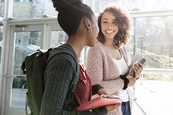 Two teens smiling and walking together