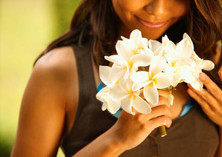 Woman smelling beautiful flowers and smiling