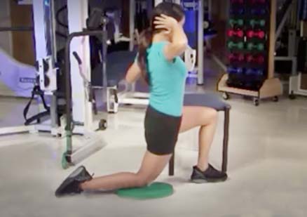 woman stretches back in gym
