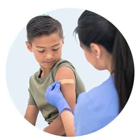 Nurse putting a bandage on a child’s upper arm