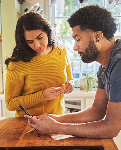 Person looking at their phone in the kitchen.