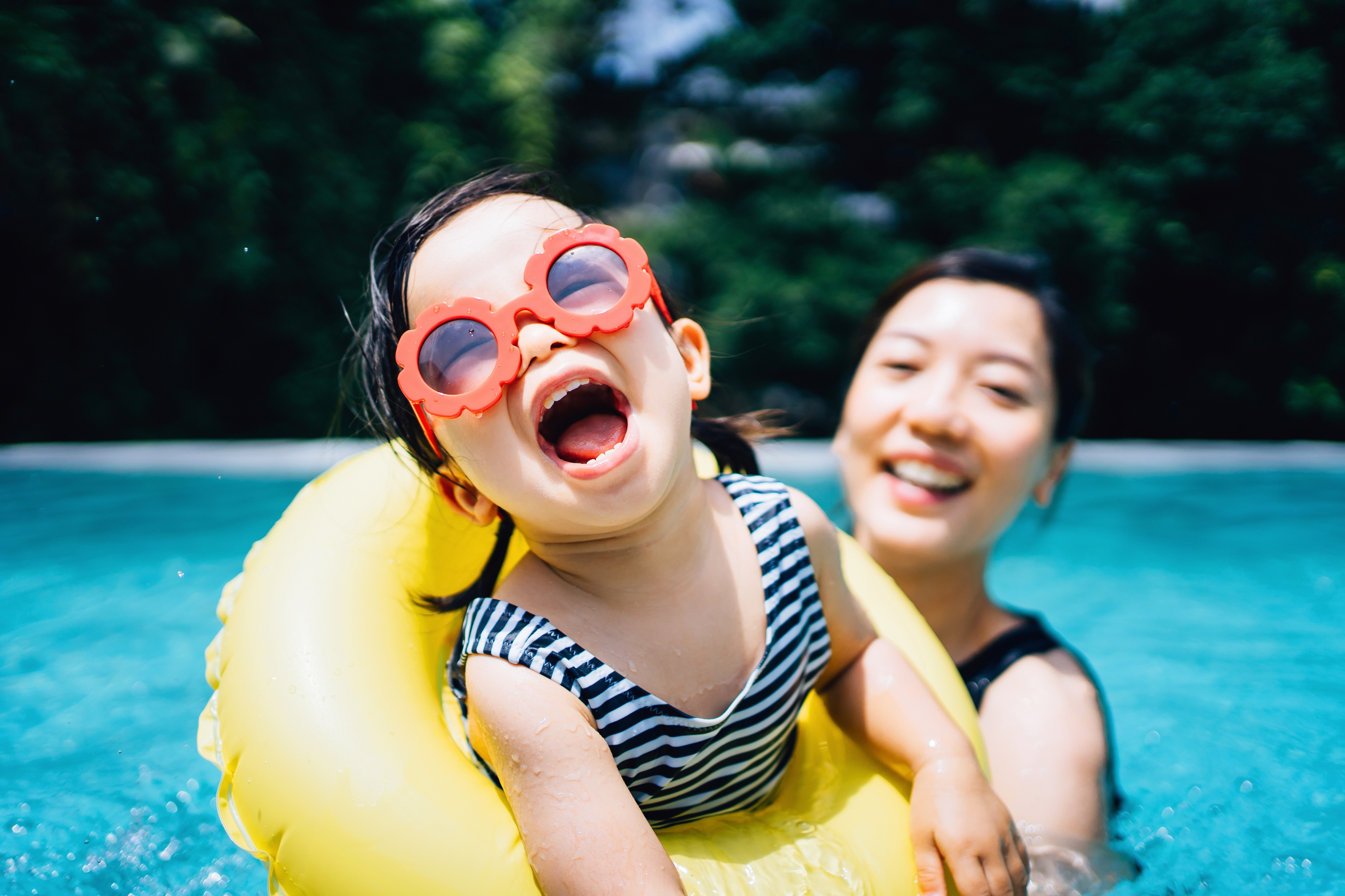Child having fun in the pool with parent