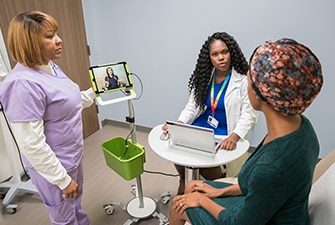 Person in exam room talking with members of their care team