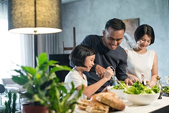 Smiling parents and young child preparing a meal