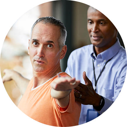 A physical therapist helping a patient perform an exercise