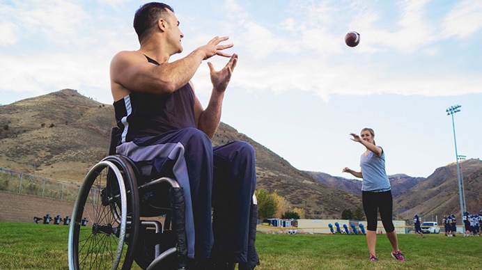 two adults playing catch with football
