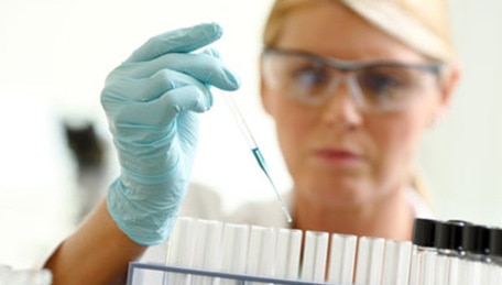 Lab worker putting liquid in vials