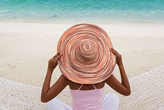 Person wearing a large sun hat at the beach