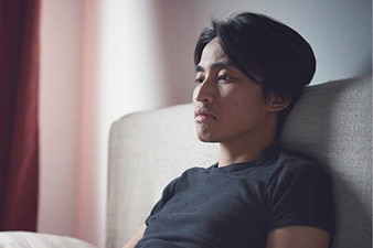 Person sitting anxiously on couch
