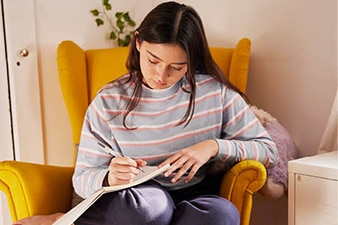 Young person sitting and journaling