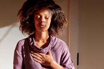 Person meditating with a hand on their chest