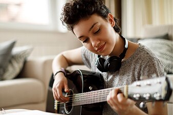 Smiling teenager playing a guitar