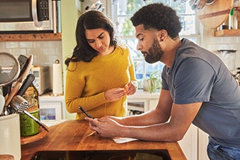 Couple in the kitchen looking at a smartphone
