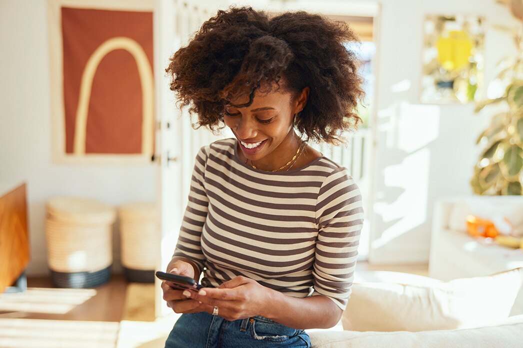 Person smiling and looking at their phone.