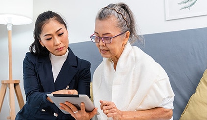 Person reviewing care options with older adult on tablet