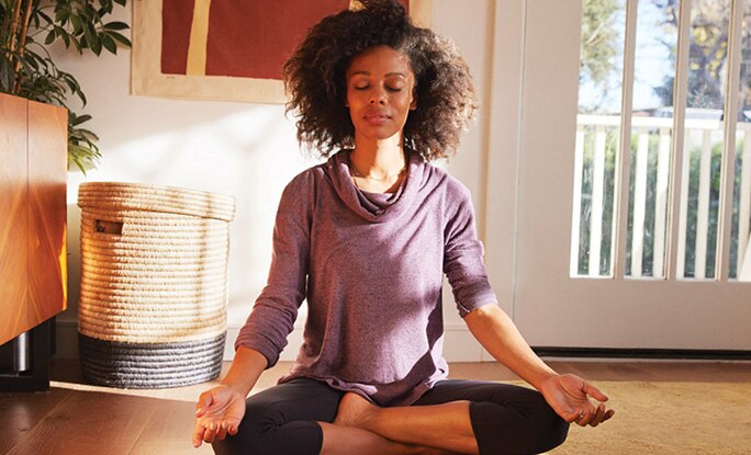 Person meditating in lotus position.