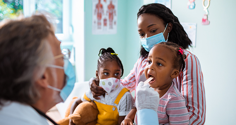 parent-holding-their-children-while-a-pediatrician-examines-them