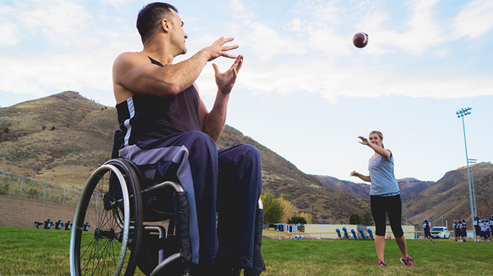 two adults playing catch with football