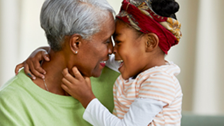 A person and a child touching noses and hugging