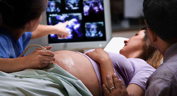 Clinician and patient reviewing a pregnancy ultrasound