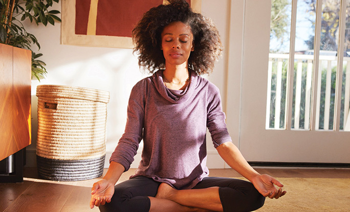 Person meditating in lotus position.