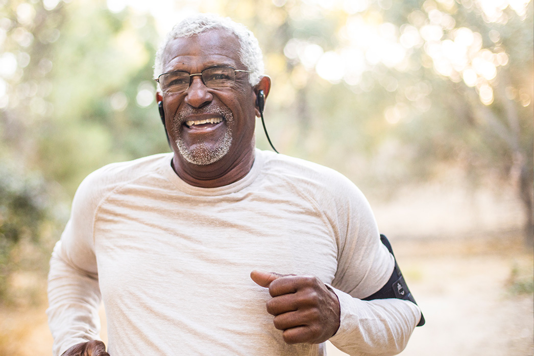 older person runs with headphones on