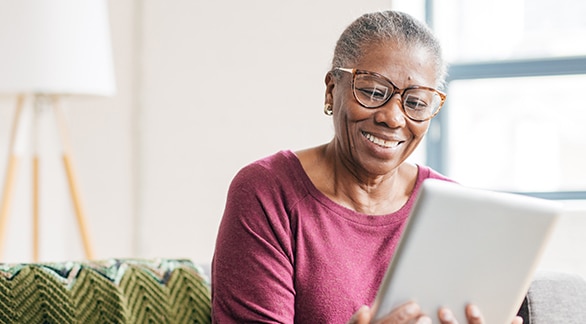 Person smiling while reading a tablet