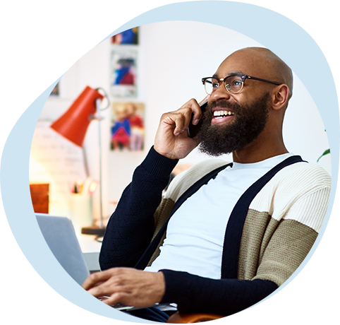 Person laughing on phone with laptop