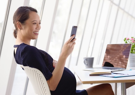 woman looking at cellphone in office