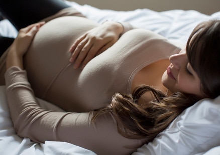 Expectant mother resting on bed